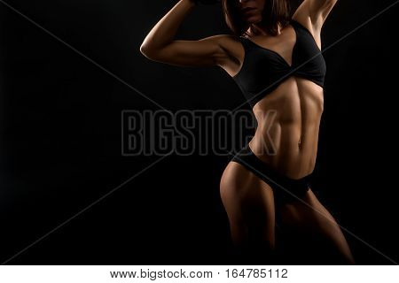 True challenger. Cropped shot of a muscular fitness woman with perfect abs posing on black background copyspace on the side