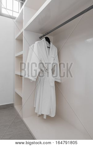 white robes with wooden hangers at dressroom
