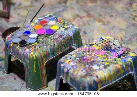Art of Painting. Paint buckets on the chair background