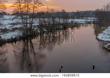 Pictorial evening landscape with Hrun' river at winter sunset time Poltavskaya oblast Ukraine