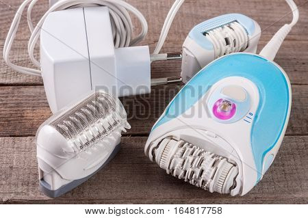 electric epilator on an old wooden background. Hair removal device