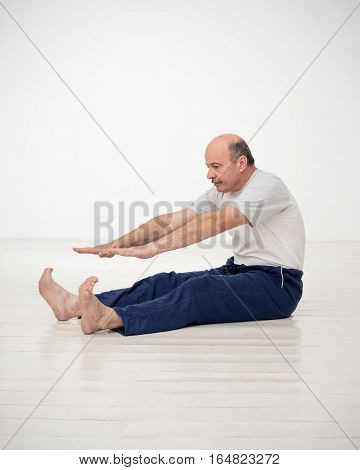 Elderly man practicing yoga or fitness. Positive mood on sports activities