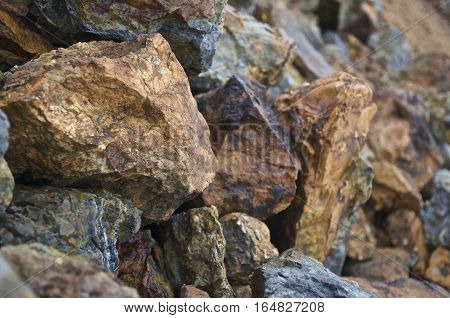 Copper mineralised rock pile, rubble tailings, close with shallow depth of field.