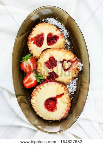 Shortbread cookies with strawberry jam or mini pies with heart decoration on Valentines Day