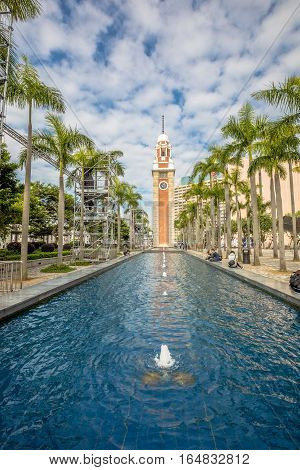 Hong Kong, China - December 5, 2016: Clock Tower with a pool at Tsim Sha Tsui. The landmark 44 meter tower is the only remnant of the original Kowloon Station on the Kowloon-Canton Railway.