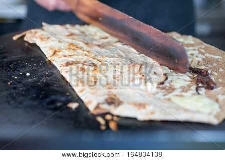 Half-cooked Crepe Being Folded With Wooden Scraper