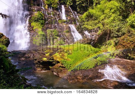 A rainbow at the base of Wachirathan Waterfall in Thailand near Chiang Mai in Doi Inthanon National Park as a rainbow formed in the mist below the falls.