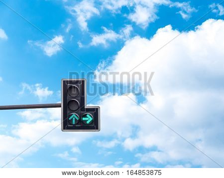 Green color on the traffic light with a beautiful blue sky in background Go straight and turn right
