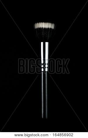 Makeup brushes lying on a black background