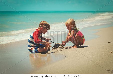 kids play with sand on summer tropical beach