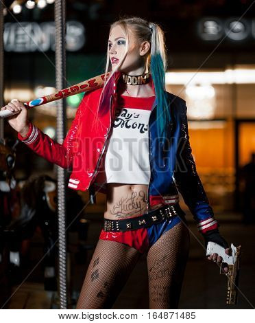 Portrait of cosplayer girl in costume Harley on background lights of night city. Cosplay