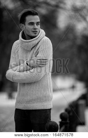 Young man in cold winter weather. He is cold and he shrank from the cold.