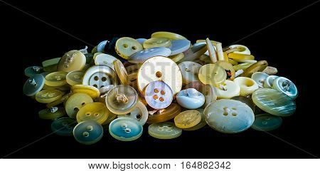 A bunch of old plastic buttons on black background