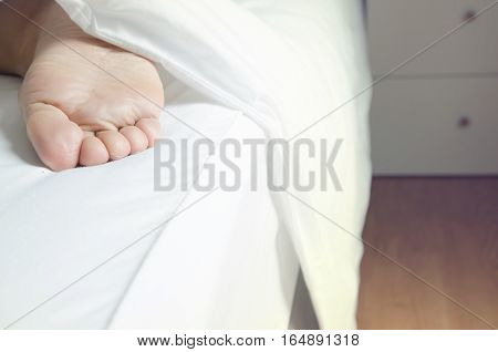 Close up feet of women sleeping women on bed After sleep long night