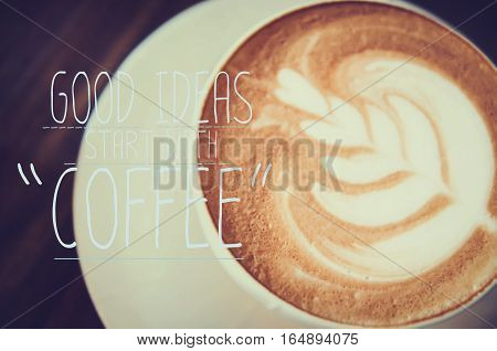 hot milk art coffee on wooden table with qoute on photo