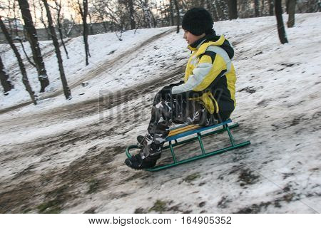 Bucharest Romania January 2 2011: A child sleighing on a hill in a park in Bucharest capital of Romania during a cold day. The meteorologist announced temperatures lower than normal for this period.