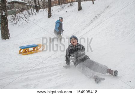 Bucharest Romania January 30 2014: Children sleighing on a hill in a park in Bucharest capital of Romania during a cold day. The meteorologist announced temperatures lower than normal for this period.