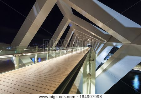 DUBAI UAE - NOV 29 2016: New pedestrian bridge over the Dubai Water Canal illuminated at night. United Arab Emirates Middle East