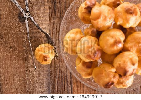 Group of sweet cream puffs on glass tray.