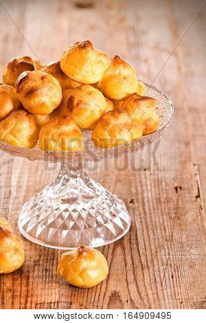 Group of sweet cream puffs on glass tray.