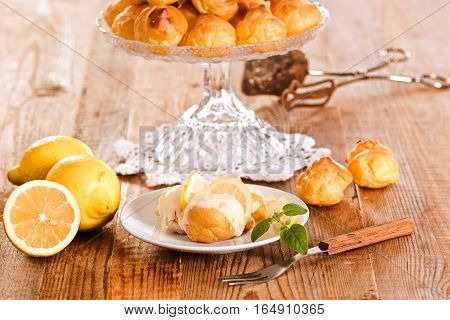 Lemon Profiteroles with custard cream on white dish.