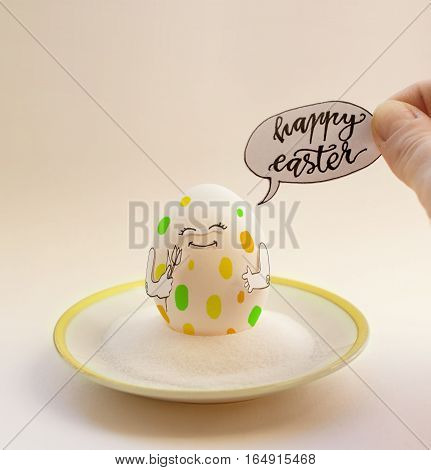 Nice egg on a saucer with hands smiling. Happy easter