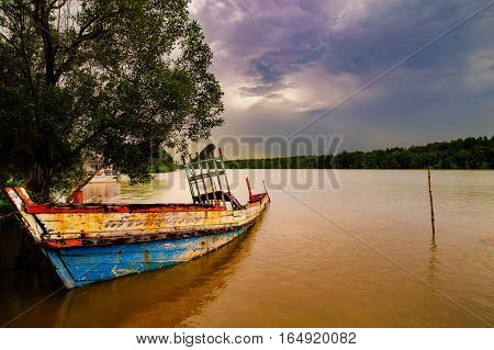 A old sunken crab boat grounded along Krabi river side on the Andaman penisula in Thailand