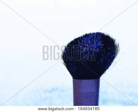 soft cosmetics brush with blue sparkle glister isolated on white copy space