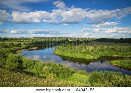 Big, beautiful North river on a Sunny day flows slowly between the fields and villages.