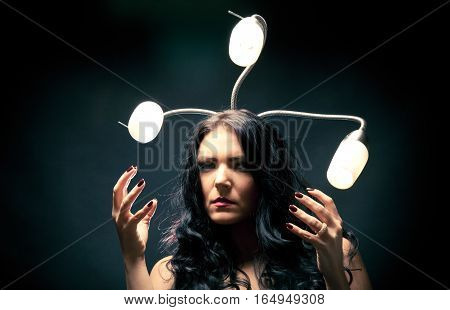 young woman with snakelike lamps behind her head. really scary.