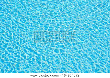 Blue ripped water in swimming pool. Pool water background. Swimming pool with stair in hotel. Summer photo concept.