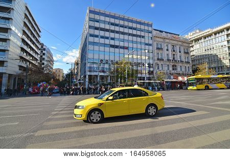 SYNTAGMA ATHENS GREECE, DECEMBER 18 2016: yellow taxi and people waiting to cross the road at Syntagma Athens Greece. Editorial use.