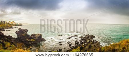 Panorama view of famous tourist attraction in Jeju Island South Korea. Yongduam also known as dragon head rock that was created by strong winds and waves over thousands of years.