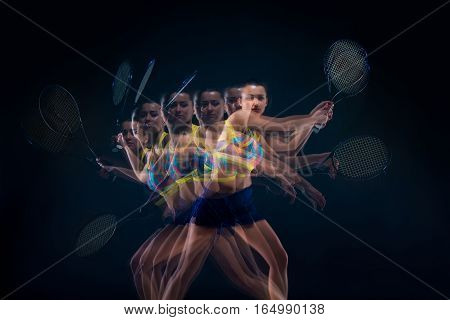 Portrait of beautiful girl tennis player with a racket on dark studio background. Stroboscope shooting technique