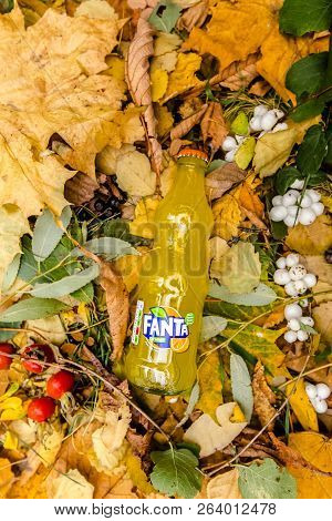 Saint-petersburg, Russia, 17 10 2018 Fanta In A Glass Tin Bottle On Autumn Yellow Green Foliage Of T