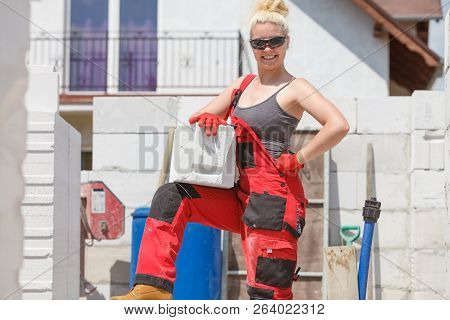Strong Pretty Woman Working On Construction Site, Building House, Installing Gray Airbricks. Industr