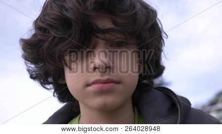 Cute Teenager With Curly Hair Against The Blue Sky