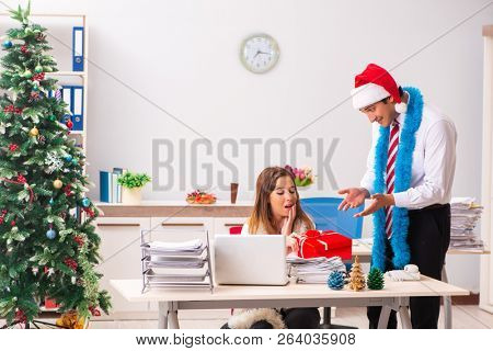 Colleagues exchaing christmas presents in office