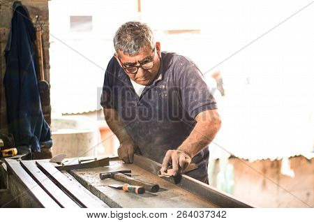 Professional Carpenter Sanding And Refinishing Wood Surface.