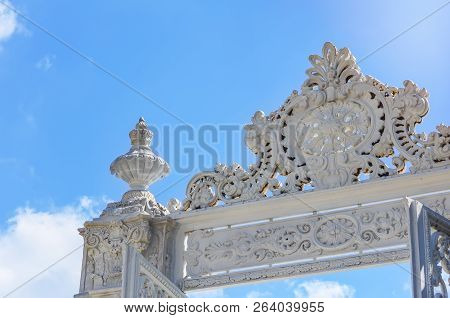 Upper Fragment Of The White Carved Marble Gate Of The Dolmabahche Palace Against A Blue Sky.