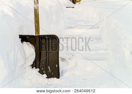Snow Shovel In The Snowdrift During The Blizzard. Shovel For Cleaning The Footpaths From Snow.