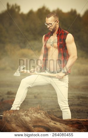 Fitness Tattooed Bodybuilder With Double Edge Axe Outdoor In Sunny Day
