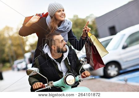 Portrait of happy couple with shopping bags after shopping in city
