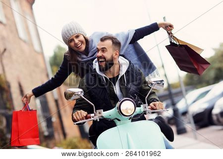 Portrait of happy couple with shopping bags after shopping in city