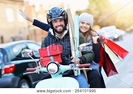 Portrait of happy couple with shopping bags after shopping in city