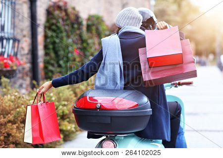 Portrait of happy couple with shopping bags after shopping in city