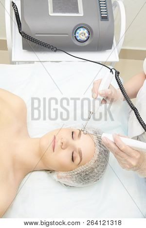 Facial Micro Current Cosmetology Procedure. Beauty Technology Treatment. Woman Face Therapy