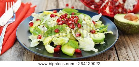 Vegetarian Salad With Avocado, Greens, Leaves, Pomegranate And Letuce Leaves. Wooden Rustic Table.