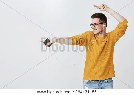 Guy Rocking Dance-floor As Listening Music In Earphones, Dancing And Pointing Left At Copy Space Fee