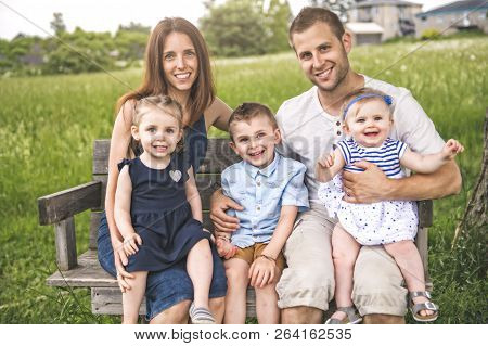 Family Spending Time With Little Child During The Sunset.